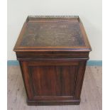 A 19c Goncalo Alves Davenport of substantial form with sliding top having a three quarter gilt brass