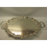 A late Victorian two handled silver tea tray with a raised shaped border cast with leaf and shell,