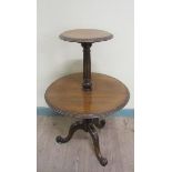 A 19c mahogany two tier dumb waiter, revolving and having a fluted and baluster turned column on