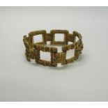 An 1950s 9ct gold bracelet of large square link design with bark texture - 61g.