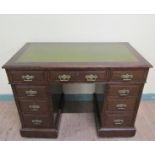 A late Victorian oak pedestal desk of rectangular form, the top with moulded edge and having a green