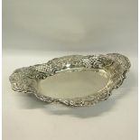 A late Victorian oval silver fruit bowl with raised and shaped pierced border embossed with flowers,
