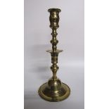 An 18c bronze bell base candlestick with a knop double column with central drip pan and baluster