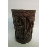 A 19c Oriental bamboo brush pot carved in high relief with village in a bamboo setting. 12cms dia