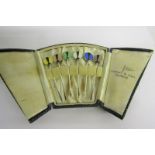A boxed set of silver art deco cocktail sticks with circular coloured terminals, retailed by