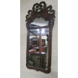 A William and Mary style figured walnut veneered wall mirror with open scrolling pediment, arched