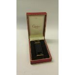 A Cartier of Paris Plaque lighter or G28407V with black enamel and gilt case. In original box.