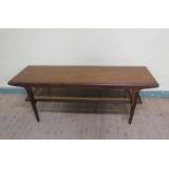 A 1970s teak low table of rectangular form with a caned under tier shelf, supported on straight