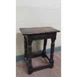 An oak joint stool of rectangular form with moulded edge with baluster ring turned legs on block