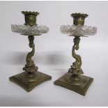 A pair of late 19c ormolu candlesticks with dolphin columns, cut glass drip pans supported on square