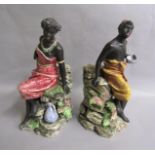 A pair of 19c Continental spill vase figures of an African couple, each seated on a stepped base
