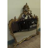 A mid Georgian style gilt wooden stucco wall mirror with a rising leaf and scroll pediment within