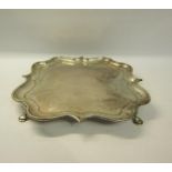 An Edwardian silver salver of quatrefoil form with raised shape border supported on four hoofed