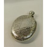 An Edwardian silver pocket flask of oval form incised with bands of scrollwork and flowers with a