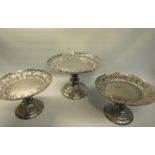 A late Victorian silver tazza garniture of three table comports. Dishes of circular form supported