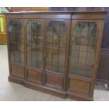 A late 19c/early 20c oak breakfront standing bookcase with fitted shelves and enclosed by glazed