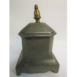 An early 19c lead tobacco box with lift off cover having a brass finial and supported on a shaped