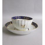 A Worcester fluted tea bowl and saucer with blue and gilt border, gilt Thistle reserved in base.