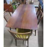 A 1970's teak dining table together with a set of six spindle back dining chairs with faux leather