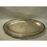 A South American silver oval dish with a raised beaded and incised shaped border. 62cms w. 54ozt