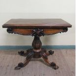 A William IV rosewood fold over card table with scroll moulded frieze supported on a lobed