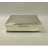 A silver cigarette box of rectangular form with engine turned panels to the hinged cover, fitted two
