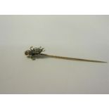 A gold stick pin with Diamond and Ruby set insect terminal. 6cms l.