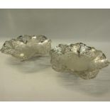 A pair of silver pierced dishes with wavy edge supported on three legs. Makers mark for Douglas