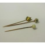 A collection of three gold stick pins, one set with Emerald and Seed Pearl, one set Opal, the