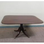 A Regency figured mahogany rosewood and brass rail cross banded breakfast table, tilt top on a