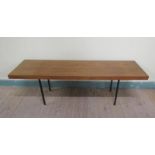 A 1970's teak low table of rectangular form supported on black painted straight steel legs. 140cms w
