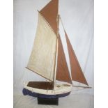 An old wooden model pond yacht with linen sails adapted for radio control,