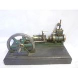 A large old horizontal steam pumping engine with fly wheel on rectangular base,