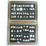 A collection of 80 anodised aluminium military cap badges mounted on two display boards