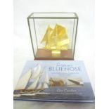 A gilt model of the Schooner "Bluenose" within small glazed rectangular case together with a