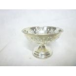 A small ornate silver circular pedestal sweetmeat dish with pierced decoration,