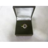 An 18ct gold dress ring set central sapphire surrounded by diamonds