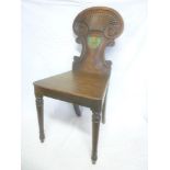 An early 19th Century carved mahogany hall chair,