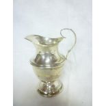 An Edward VII silver tapered cream jug with scroll handle,