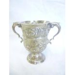 A mid 19th Century Irish silver two-handled pedestal cup decorated in relief with scrolls and
