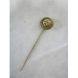 A 19th Century gilt stick pin with ceramic centre depicting a portrait of a dog