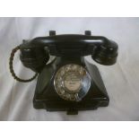 An old black telephone with chromium plated dial