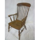 A Victorian beech & elm spindle back kitchen carver chair with shaped seat on turned tapered legs