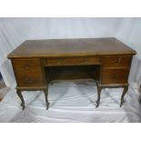An old mahogany crossbanded rectangular desk with a single drawer in the frieze and four pedestal