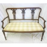 An Edwardian inlaid mahogany open arm two-seat settee with pierced vase splat back and upholstered