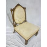 A Victorian carved walnut easy chair with seat and oval back pad upholstered art silk on turned