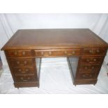 A late Victorian/Edwardian oak rectangular pedestal writing desk with three drawers in the frieze