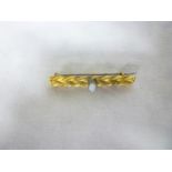 A 15ct gold bar brooch set an opal and two diamonds