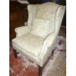 A pair of Georgian style wing easy chairs upholstered in floral fabric on mahogany legs