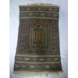 An Eastern hand-knotted wool rug with geometric decoration on blue ground,